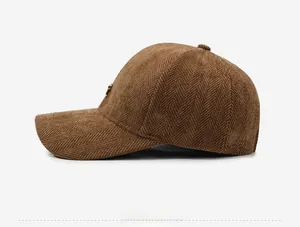 Close-up of brown herringbone tweed baseball cap with side gold metal logo detail