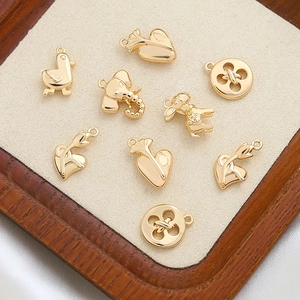 Collection of gold-plated copper charms with elephant, heart, and button shapes for DIY jewelry