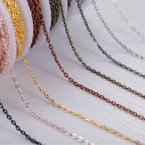 Detailed macro view of high-quality colorful metal DIY jewelry chains on a white wood surface