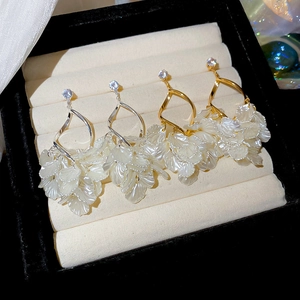 Detail of tassel petal drop earrings with zircons in gold and silver finishes