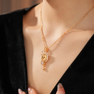 Detail of 18k gold plated necklace with zircon star pony pendant on female model