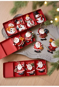 Detail view of retro resin Santa and snowman ornaments in a festive red gift box
