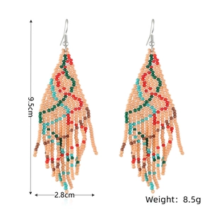 Detail view of handmade beaded tassel earrings with Christmas tree pattern and size metrics