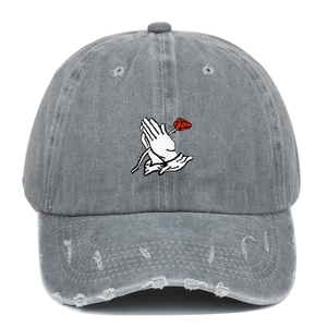 Close-up of vintage washed gray baseball cap featuring praying hands and rose embroidery