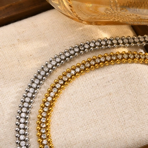 Macro view of gold and silver triple-layered chain bracelets with clear cubic zirconia stones
