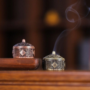 Miniature antique alloy incense burner with woven texture and hollow lid on wood tray