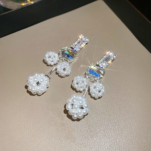 Macro view of crystal drop earrings featuring aurora crystals and sparkling pearl spheres
