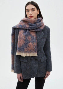 Detailed view of floral jacquard scarf in blue and orange with tassel fringe texture