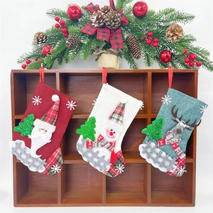 Set of 3 Christmas stockings with Santa, Snowman, and Reindeer hung on wooden decor