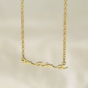 Vue détaillée d'un collier doré avec pendentif écriture Mama sur fond en tissu doux