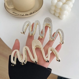 Elegant wavy shark hair clips with silver rhinestones and white pearls on gold metal base