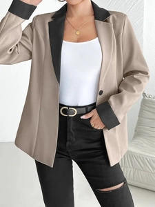 Détail d'un élégant blazer beige contrasté avec revers noirs et design à boutonnage simple