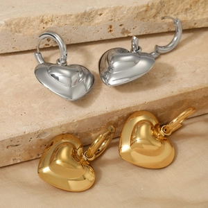 Polished hollow heart earrings in gold and silver finish on a premium silk fabric