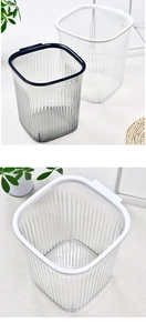 Vertical striped transparent plastic waste bin with white rim in a bright room setting
