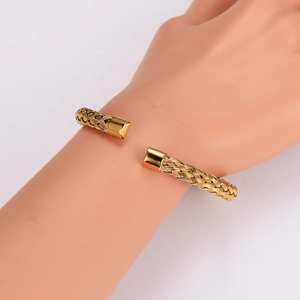 Minimalist gold woven twisted cuff bracelet shown on model wrist with open C-shape design