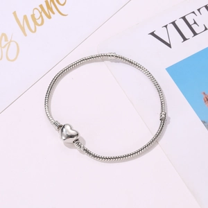 3mm silver-plated snake chain bracelet with minimalist heart clasp on white background