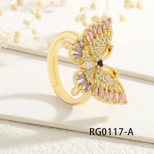 Close-up of golden butterfly ring with pink and purple zircon stones on a soft background