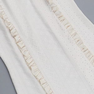 Nahaufnahme von weißem Spitzenstoff mit detaillierter Stickerei und Rüschendetails