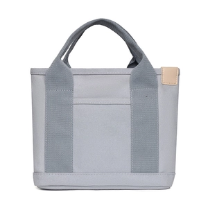 Close-up of gray canvas lunch bag featuring two-tone design and side decorative label