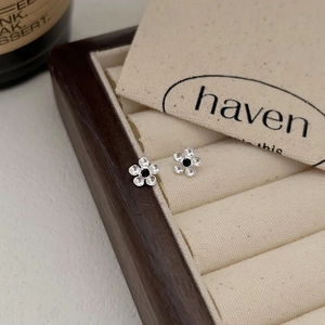 Minimalist 925 sterling silver flower stud earrings with black zircon center in a jewelry box