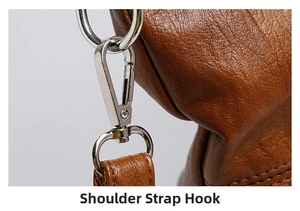 Detail of detachable silver metal swivel hook on brown litchi pattern leather tote bag