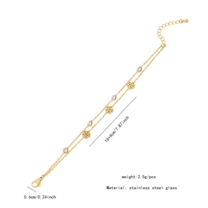 Close-up of double-layer gold stainless steel bracelet with rose charm and glass pendant