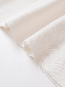 Close-up of the premium ribbed knit fabric texture on a white summer tank top