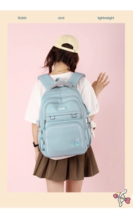 Detail of light blue waterproof backpack with plush bear charm and JLD embroidery