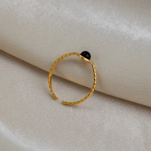Gros plan sur la bague ouverte plaquée or 18 carats avec incrustation de pierre noire