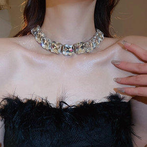 Macro shot of silver-colored necklace with large square-cut crystals on a model's neck