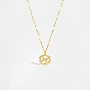 Detailed macro view of gold constellation pendant with white zircon stones on long chain