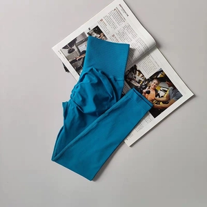 Macro shot of peacock blue high-waist yoga pants with seamless texture and ruched bum detail