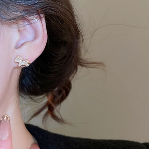 Close-up of gold plated unicorn stud earrings featuring delicate textured surface detail