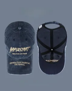 Detail of washed denim baseball cap featuring gold embroidery and adjustable metal buckle