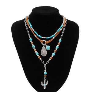 Macro shot of a layered turquoise beaded necklace set with a silver cactus pendant
