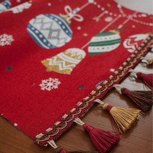 Christmas table runner with red jacquard holiday patterns, lace edges and tassels