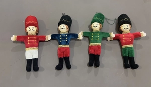 Set of four plush nutcracker Christmas ornaments with gold trim and hanging strings