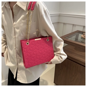 Detail of rose pink tote bag with geometric hexagonal pattern and gold chain strap