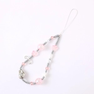 Pink sakura bead phone charm with silver bow, pearls and floral accents on white backdrop