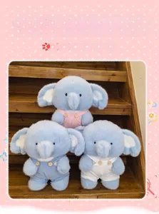 Detailed view of plush elephant dolls in colorful overalls on wooden stairs