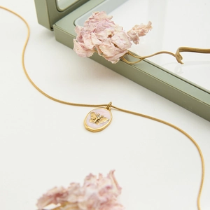 Détail du collier chaîne serpent en or 18K avec pendentif papillon émail rose et cristal