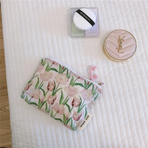 Detail of floral makeup bag with tulip print, simple wish label and pink zip puller