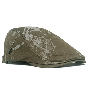 Close-up of vintage brown ivy cap featuring white abstract patterns and side metal buckle