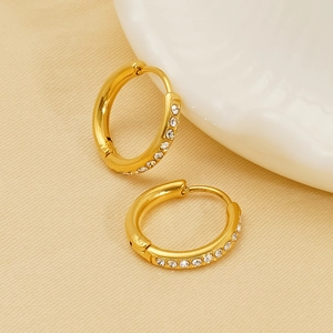18K vergoldete Creolen mit Zirkonia-Besatz auf elegantem Seidenhintergrund