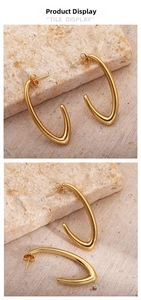 Detailed view of gold-plated U-shaped earrings on natural stone showing glossy finish