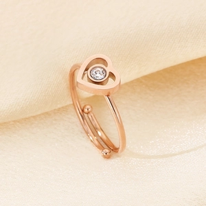 Detailaufnahme von roségoldenem Herzring mit Zirkon auf champagnerfarbenem Seidenstoff