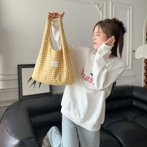 Detail of yellow gingham woven tote bag with bakka beaute label for casual daily use