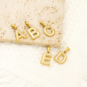 Golden stainless steel letter necklaces with white enamel on beige stone pedestals