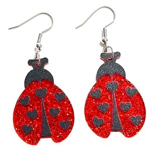 Detail of red glitter ladybug earrings with black heart spots and silver metal hooks