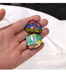 Detail view of Hawaii sunset beach enamel pins with palm tree and vintage bus designs